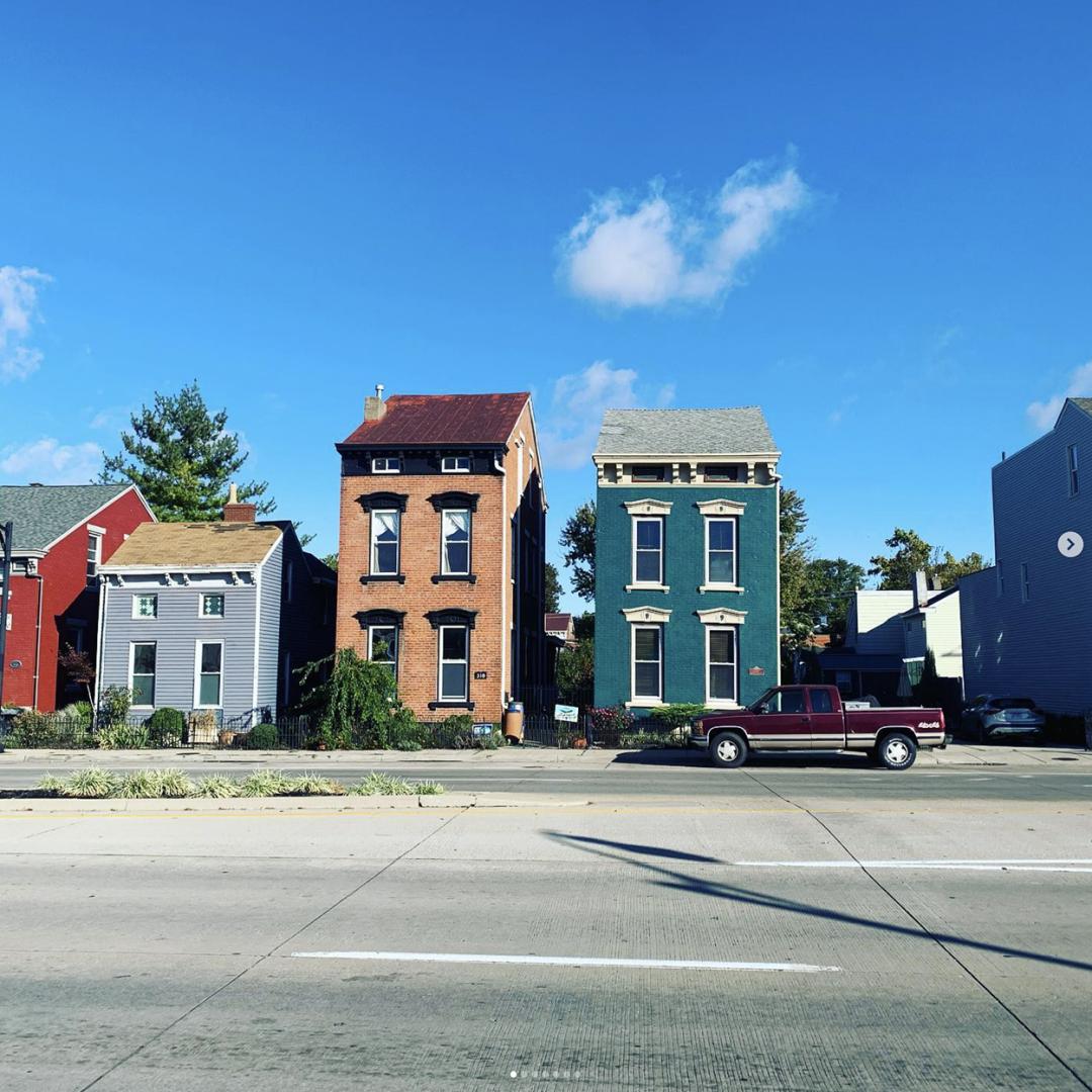 row houses beneath blue sky with a single cloud