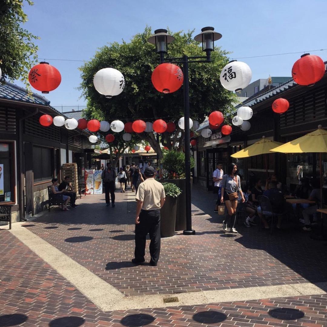 sidewalk with red and white lanterns strung above