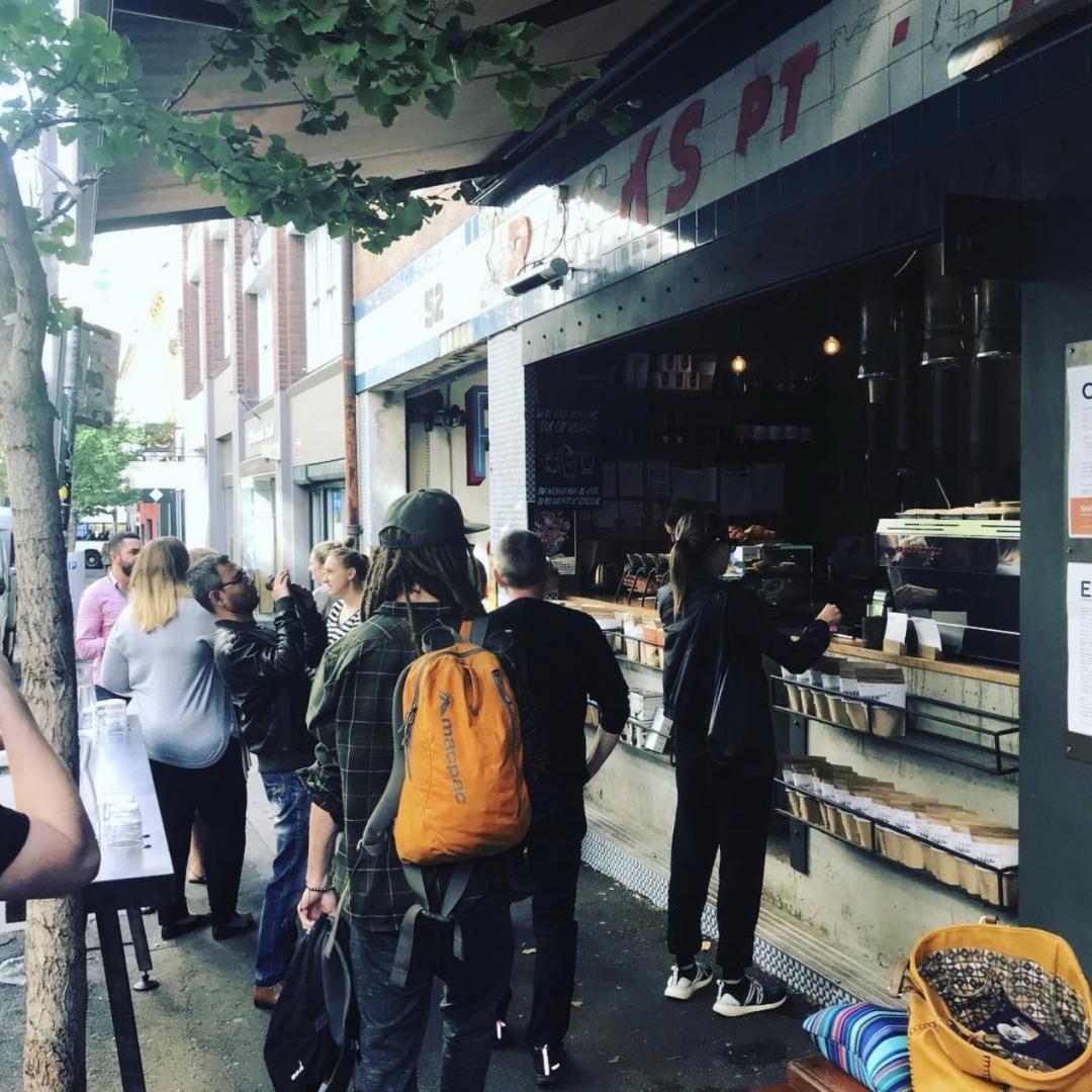 pedestrians at sidewalk coffee storefront